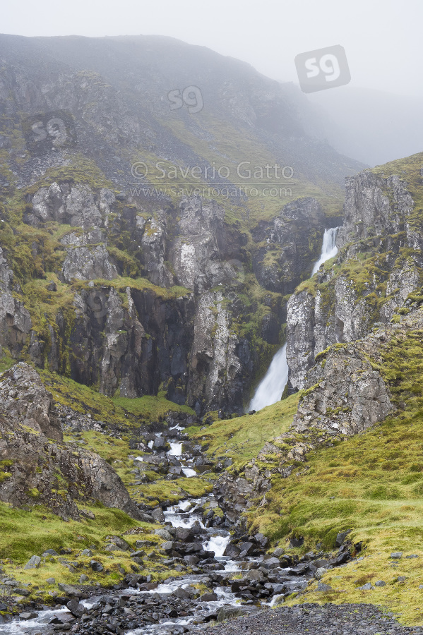 Landscape with waterfall, water flowing among steep rocks in iceland