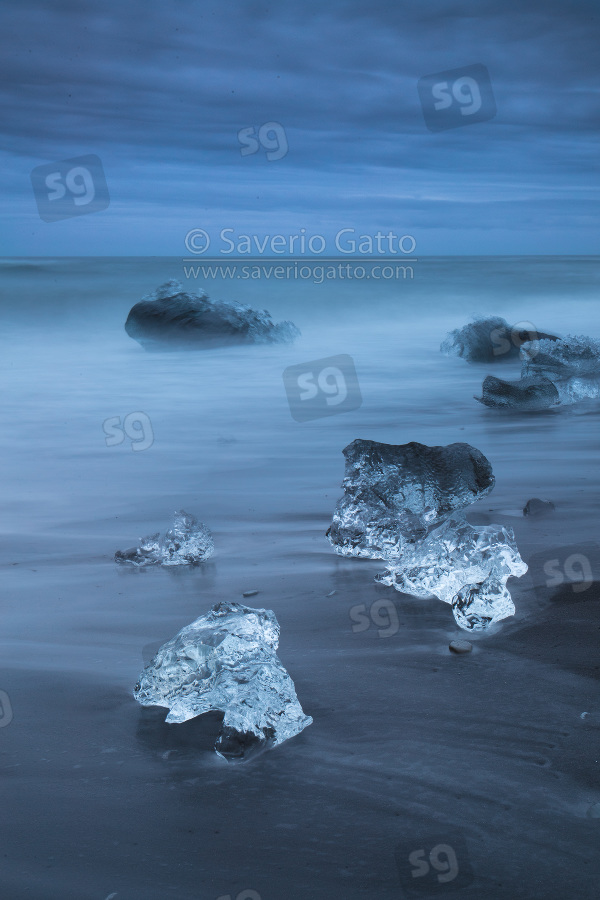 Diamond Beach (Iceland), pieces of ice on the beach with icebergs in the background